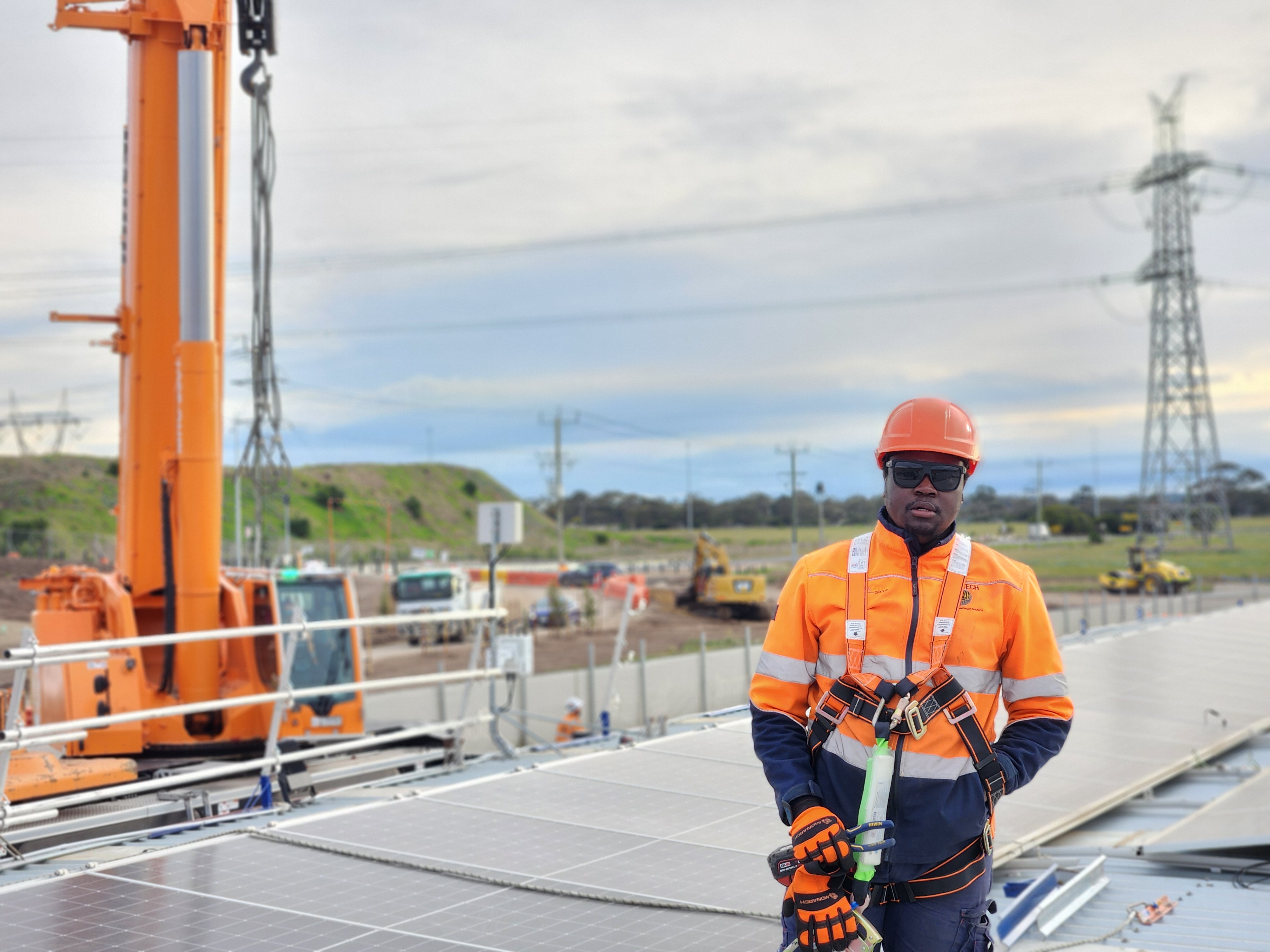 Tanasky technician in PPE installing solar panels on a residential rooftop